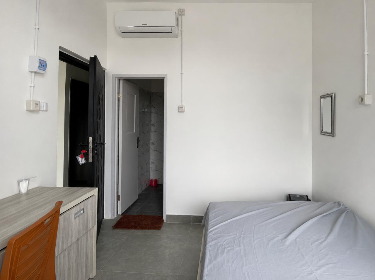 Suasana interior Kamar Utama dengan kasur, meja belajar, AC, dan kamar mandi dalam